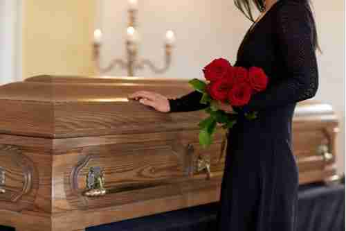 Concept of Atlanta wrongful death lawyer, young woman holding roses at funeral