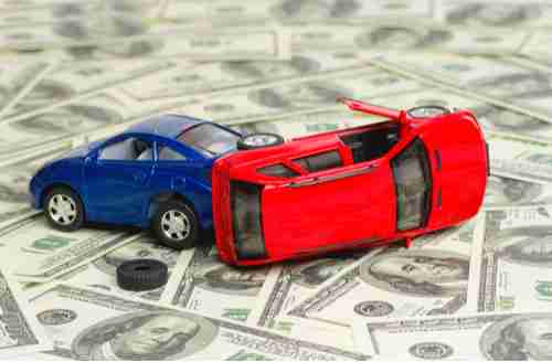 Toy cars crashed on money, car accident damages concept
