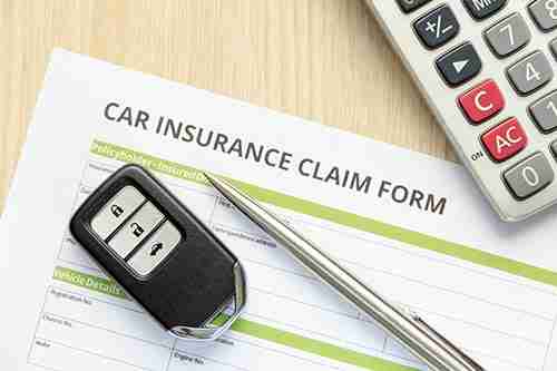Car insurance claim form with keys and calculator