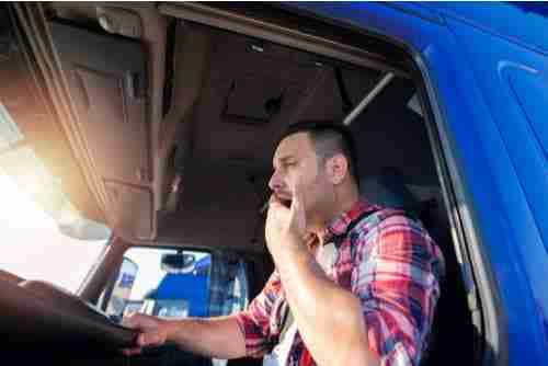 Commercial truck driver yawning, truck accident liability concept