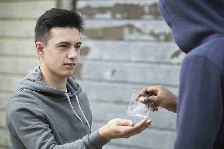 teen buys drugs on street