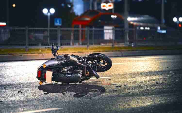 motorcycle laying on road after motorcycle accident