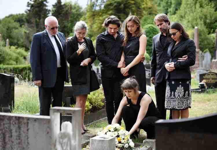 family lays flowers on a grave after the wrongful death of a loved one