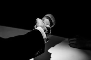 men shaking hands in secret racketeering agreement
