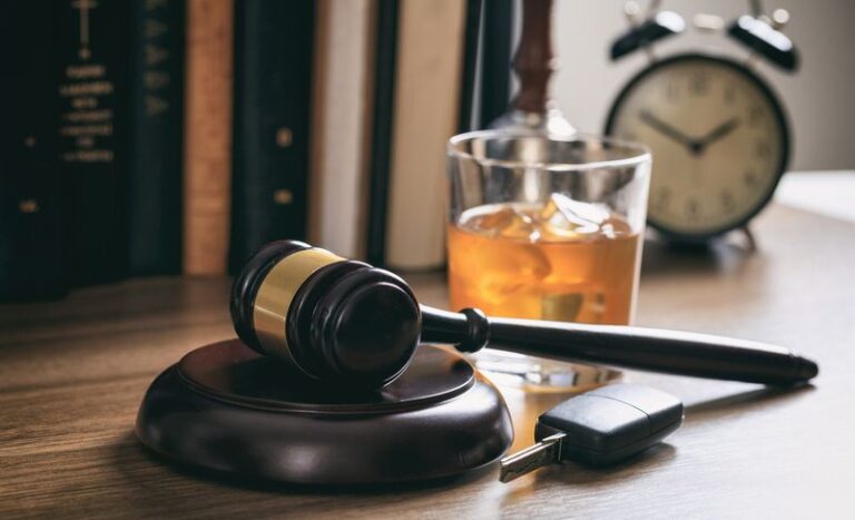 Image is of a gavel, a car key, and a glass of whiskey, concept of 5 things to know about DUI trials in georgia