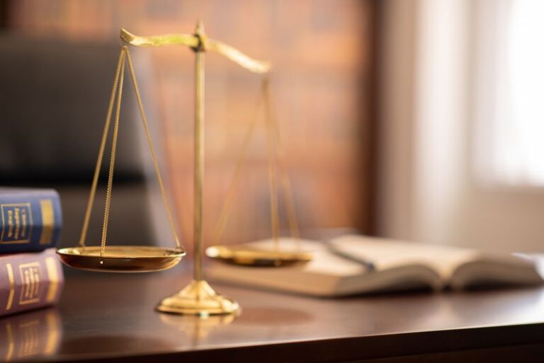 Image is of scales of justice on a lawyers desk concept of the differences of civil law and criminal law