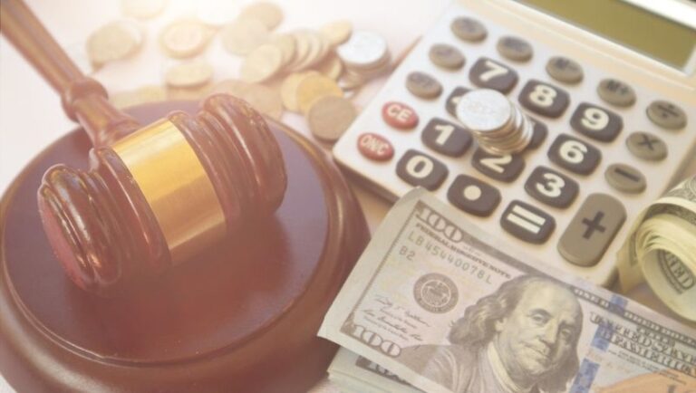 Image is of a gavel, calculator, and money, concept of what are the types of compensation in a personal injury case?